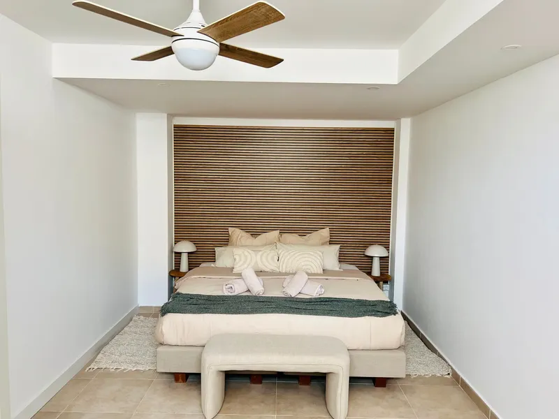 Grote slaapkamer met kingsize bed en houten wand