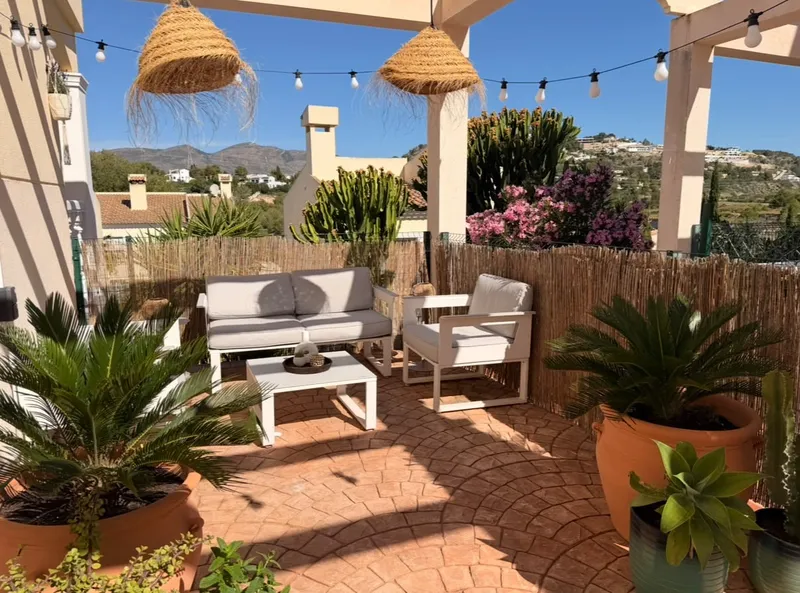Terras met loungebank, palmen en sfeerverlichting